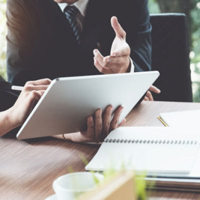 Business woman and lawyers discussing and using digital tablet  on wooden desk in office. Law, legal services, advice, Justice concept.